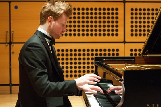 Rob playing a grand piano in a recital room